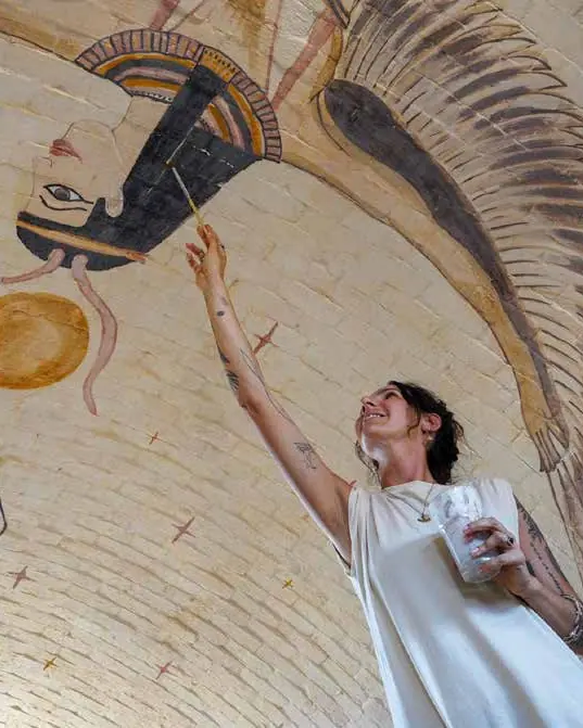 Painter working on an Egyptian-style mural