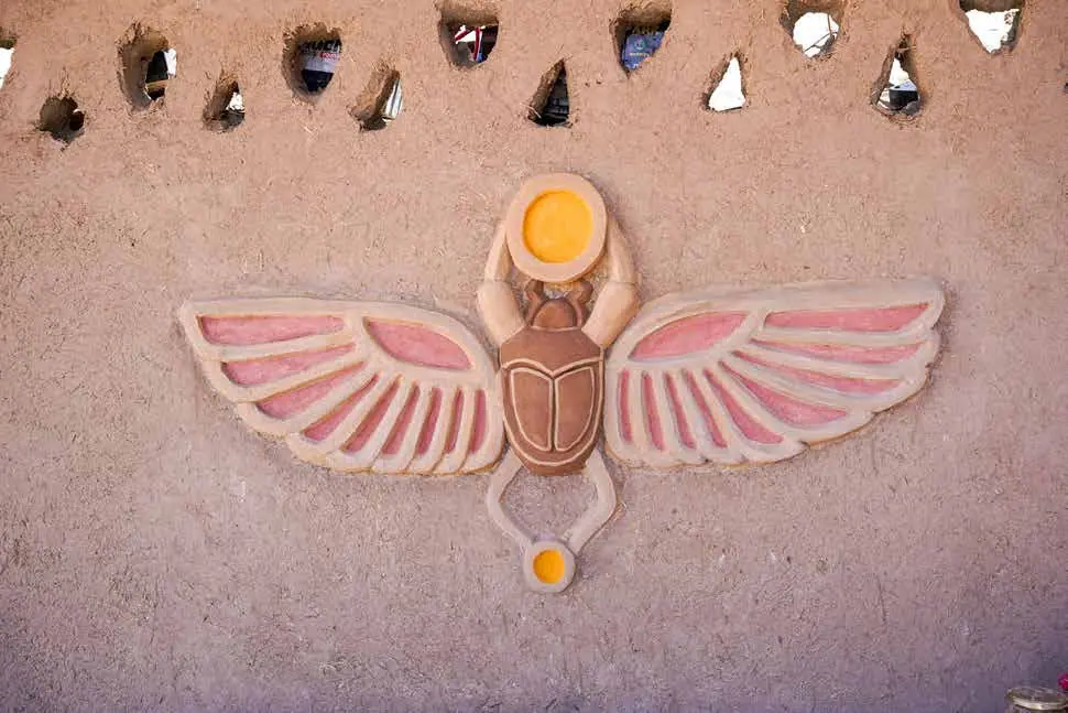 Winged scarab relief sculpted in a mud wall