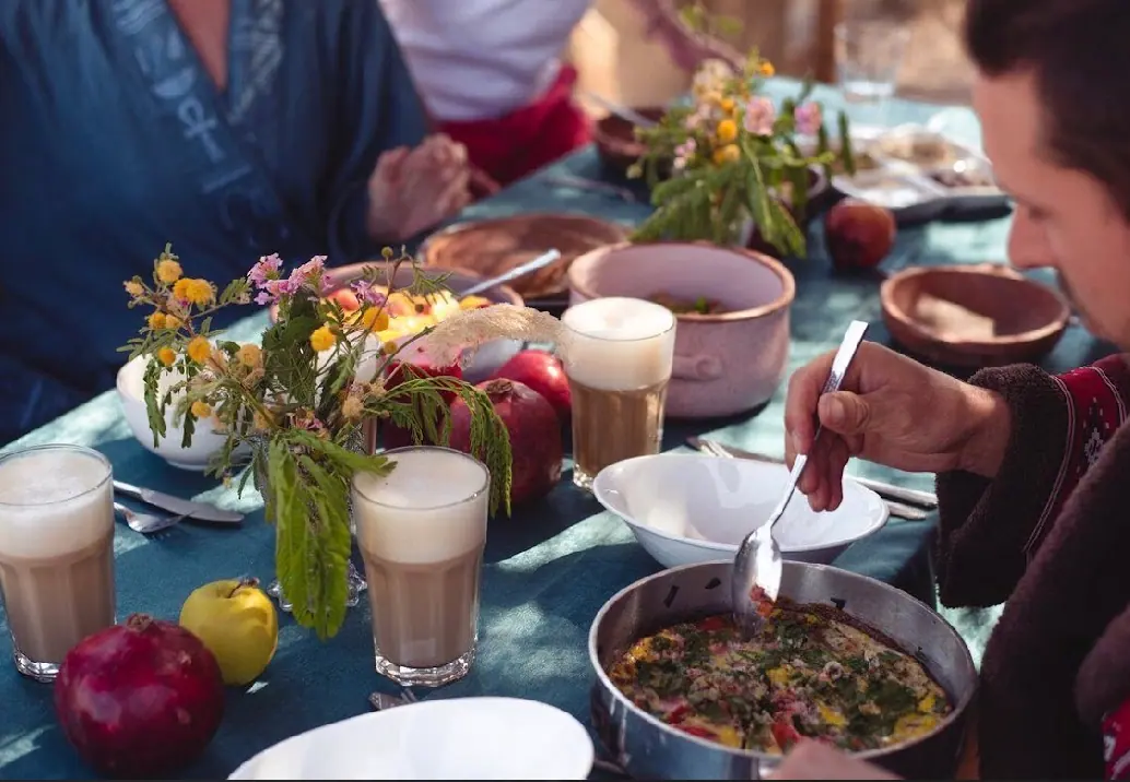A shared meal around a table of colorful dishes and flowers